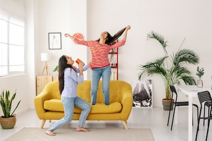 young women dancing at home as they talk about cancer sign compatibility