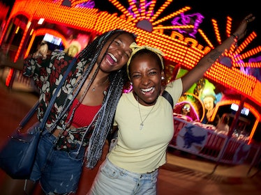 Two friends laughing at an amusement park during Neptune retrograde 2023.