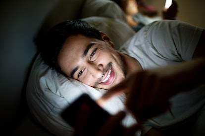 Person sending their partner a sexy text before bedtime.
